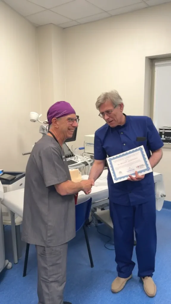Professor Mykhailo Bolgov holding a personalized certificate and shaking hands with Professor Stefano Spiezia.