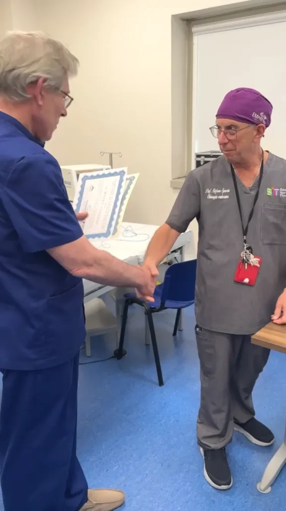 Professor Mykhailo Bolgov shaking hands with Italian Professor Stefano Spiezia while receiving a certificate.